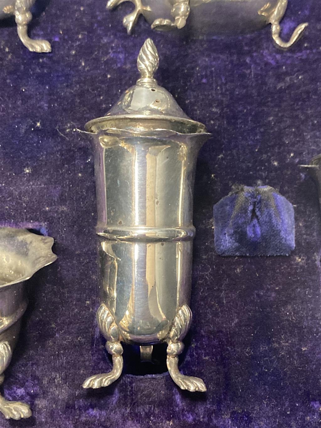 An Edwardian cased seven piece silver condiment set, Birmingham, 1907, (lacking spoons).